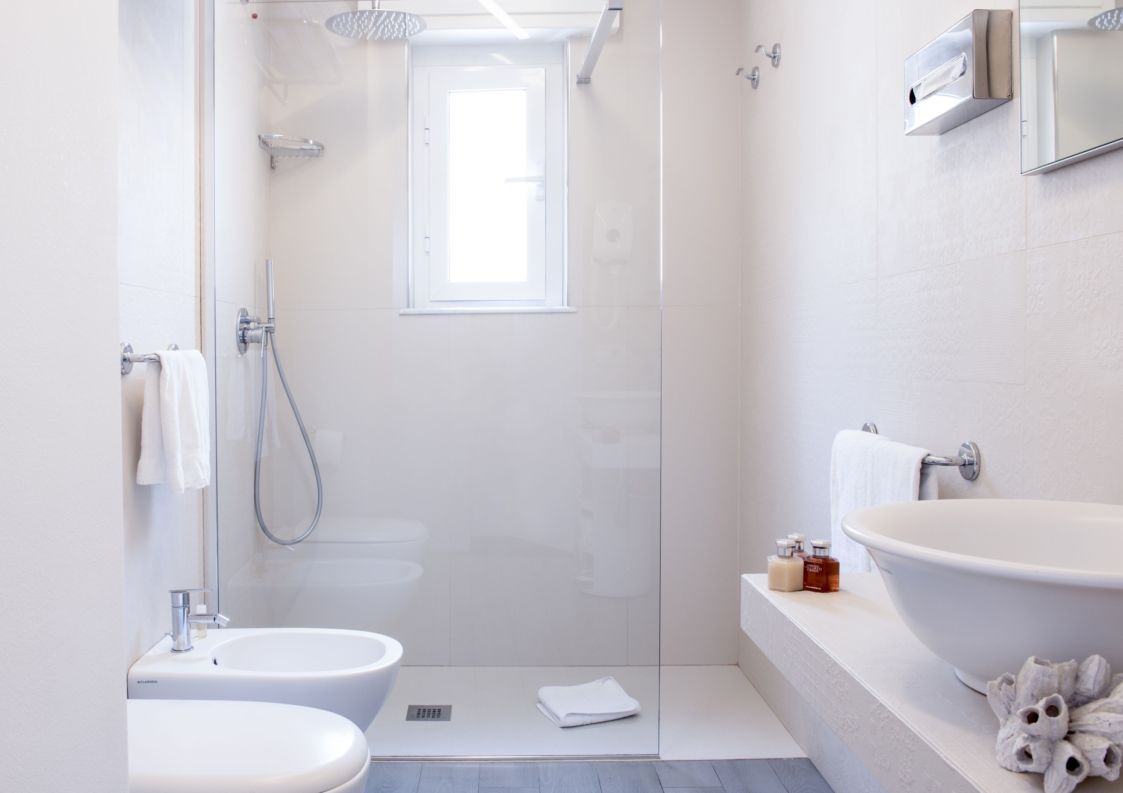 A modern bathroom with a glass-enclosed shower, a large sink, and a toilet.
