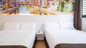 Habitación de hotel con dos camas, una mesita de noche y un mural de un paisaje urbano.