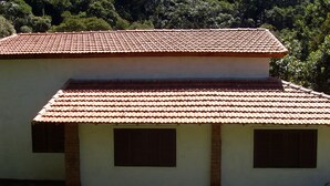 Un bâtiment à deux étages, doté d’un toit recouvert de tuiles rouges et d’une façade blanche.