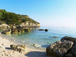 A coastal beach with clear water, rocky shoreline, and a hilly background. - Lovely 1-bed Villa in Balestrate (Balestrate)