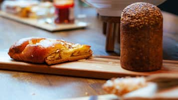 Une miche de pain et un pot sur une table en bois.
