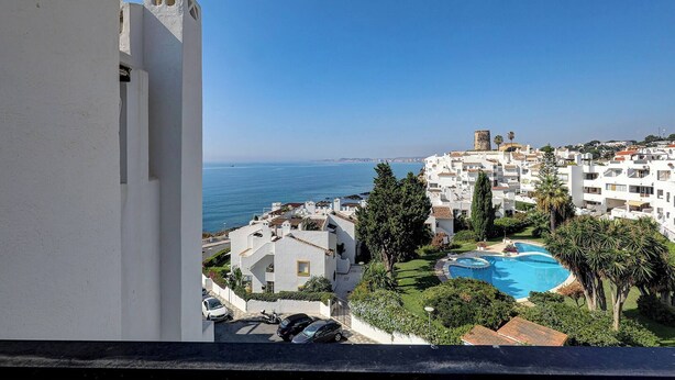 A coastal residential area with white buildings, a swimming pool, and a view of the sea. - Sea Views Beachfront Apt, Large Private Terrace (Benalmádena)