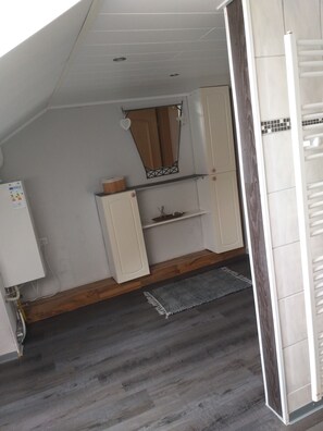 A compact kitchen with white cabinets, a small countertop, and a wooden floor. - eeeeeereeee (Krummhörn)