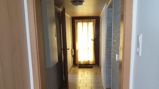 A hallway with a tiled floor, wooden doors, and a window with curtains. - Vacation home, North Sea, Krummhörn, Upleward <br> (Krummhörn)