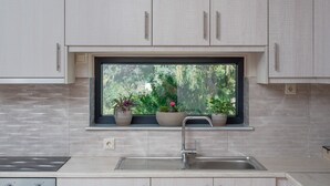 Eine Küche mit Fenster, Schränken und Spüle.