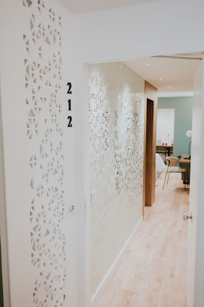 A hallway with a decorative wall featuring geometric patterns and the number 212.