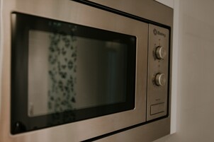 Un microondas con pantalla digital y perillas de control.