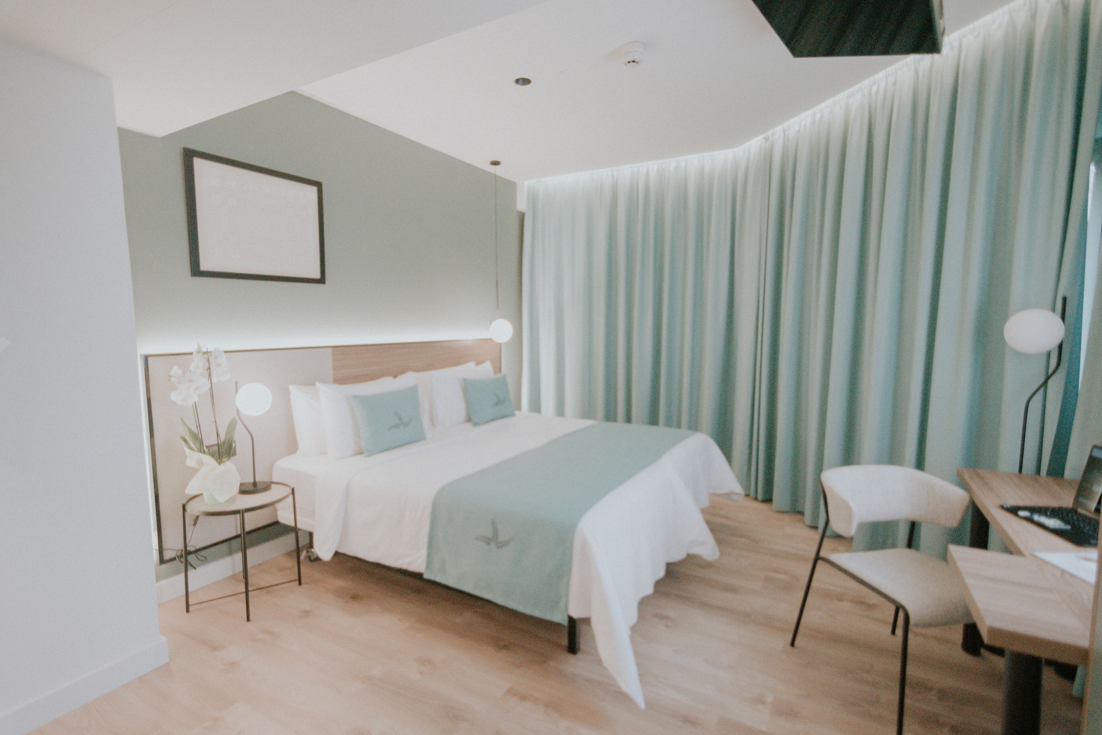 Une chambre à coucher moderne avec un lit, une table de chevet, une lampe, une chaise et un bureau.