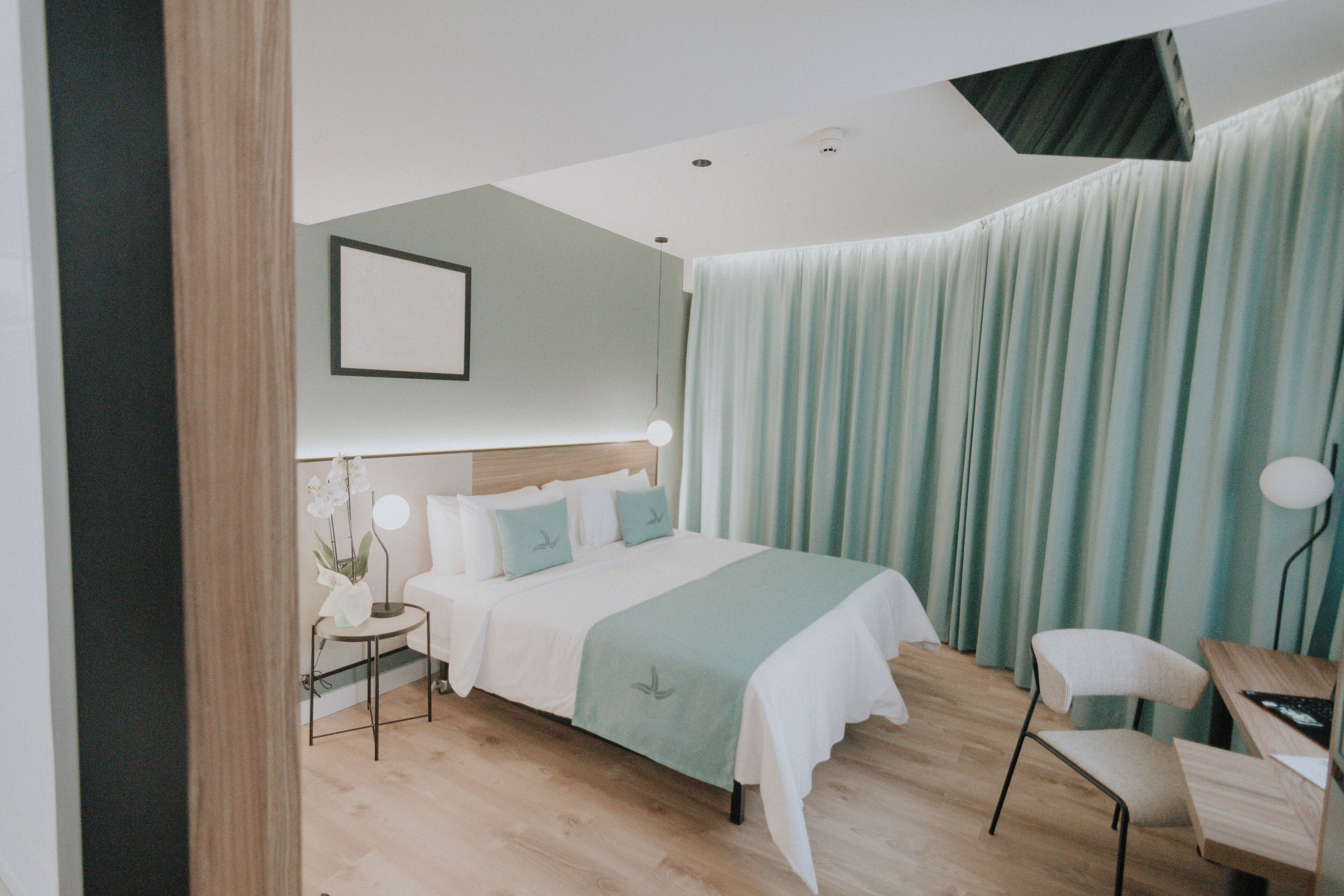 Une chambre à coucher moderne avec un lit, une table de chevet, une lampe et une chaise.