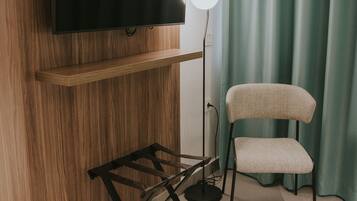A modern room with a mounted TV, a standing lamp, and a chair.