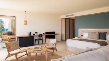 Een moderne hotelkamer met een groot bed, een slaapbank, een eettafel en een bureau met een computer.
