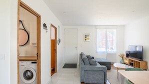 Un salon moderne avec un canapé, un téléviseur et un coin repas.