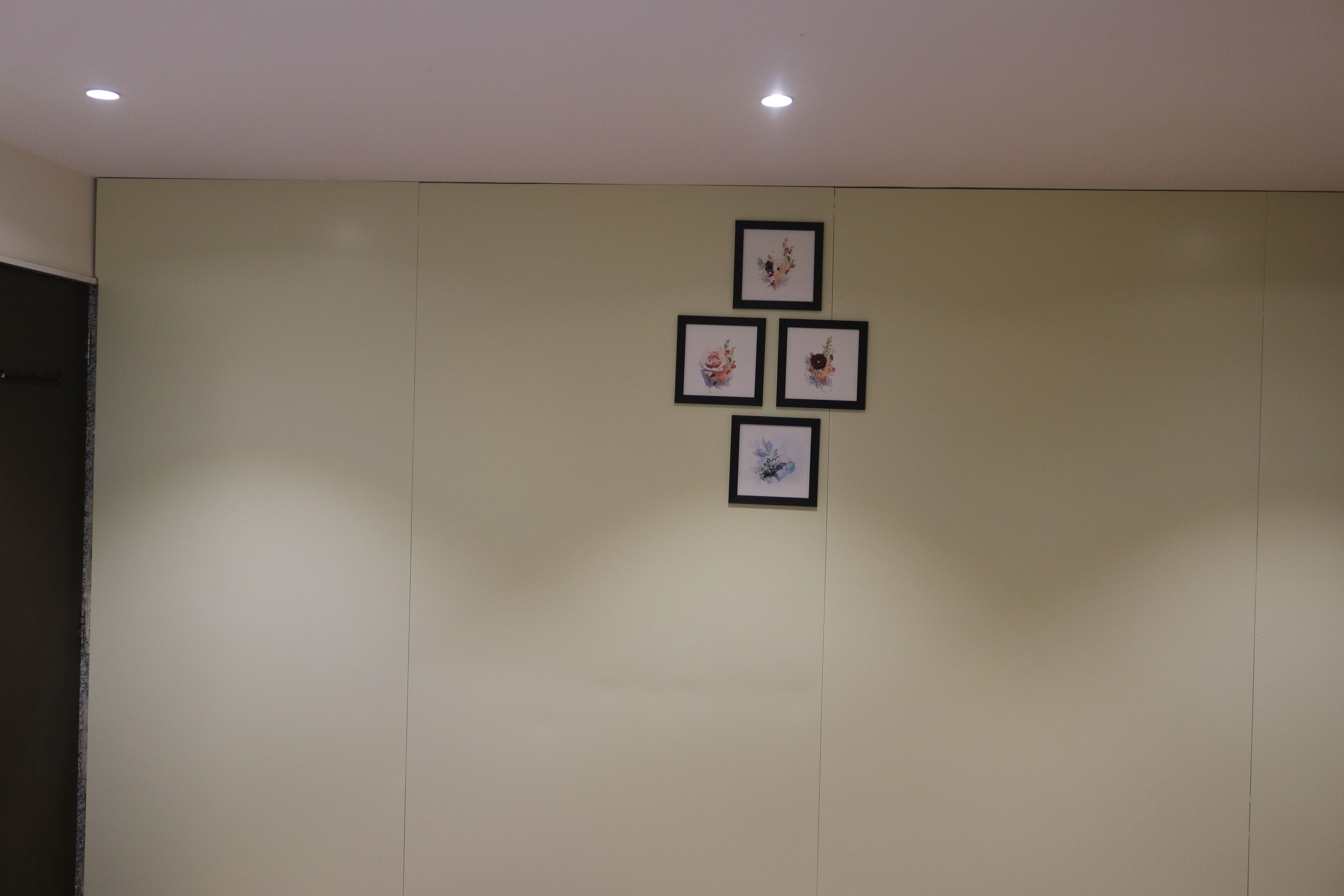 A wall with four framed pictures arranged in a square pattern.