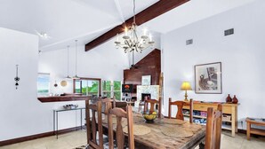 A spacious dining area with a wooden table and chairs, a chandelier, and a view of the outdoors. - Canyon Breeze I 3 Bedroom I Pet Friendly I Canyon Lake! (Canyon Lake)