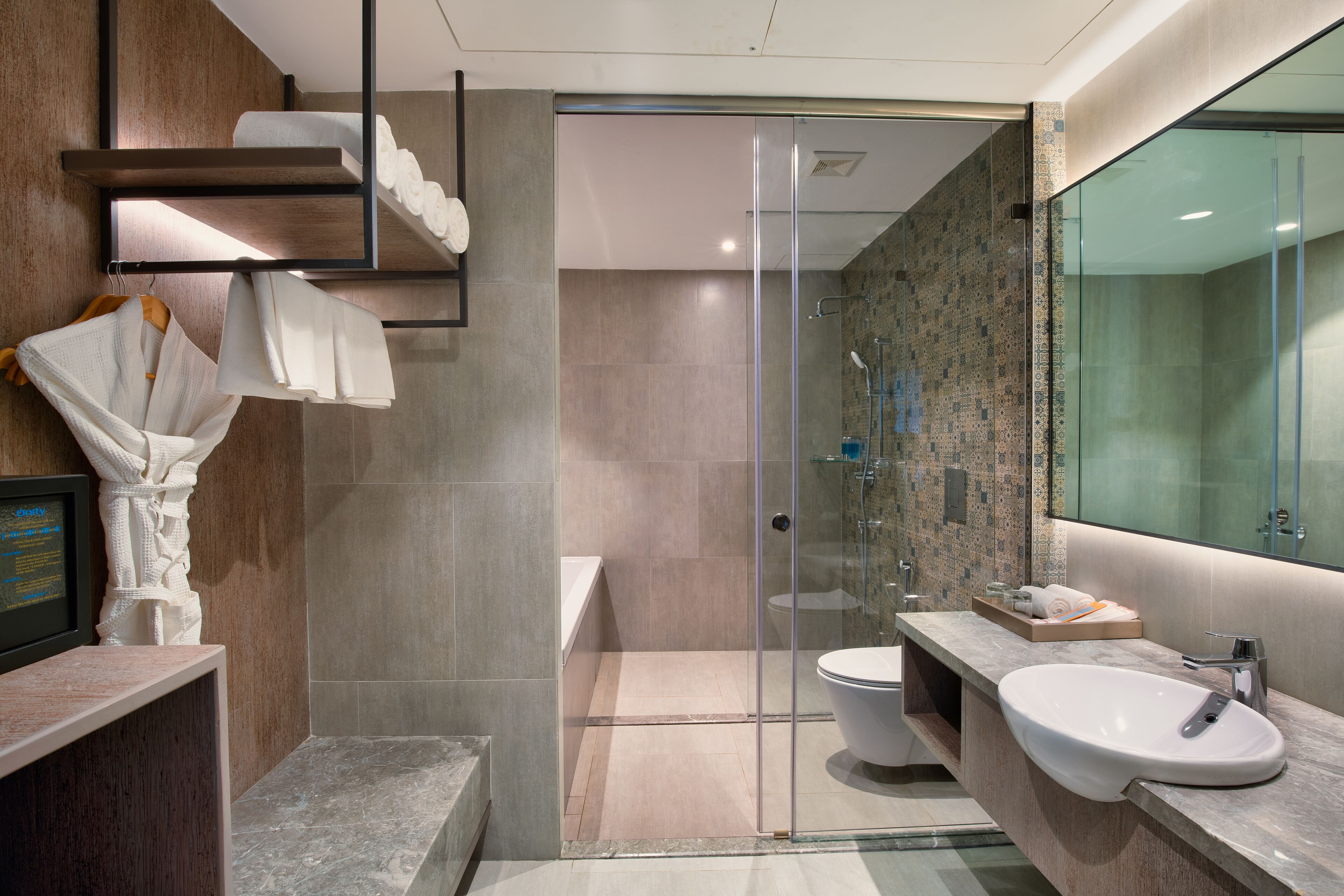 A modern bathroom with a glass shower enclosure, a marble sink, and a wooden vanity.