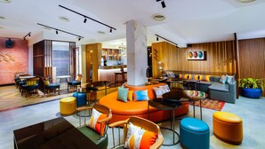 A modern interior with a central seating area, a bar, and a kitchen visible in the background. - Amoravida By 7 Apple Resorts (Pernem)