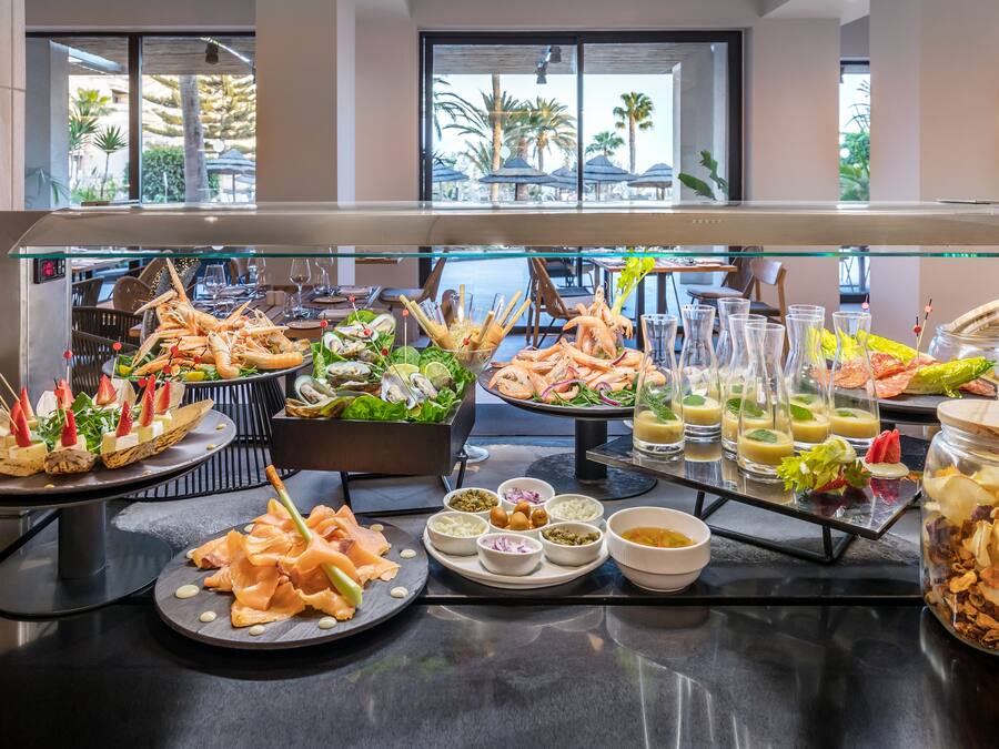 Un bufé con mariscos, ensaladas y diversas salsas.
