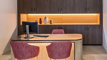 Una cocina moderna con una isla central, dos lámparas colgantes y un armario de madera arriba.