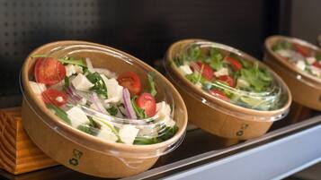 Three salad bowls with a lid on a shelf.