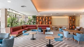 Un área de estar moderna con diferentes disposiciones de asientos, mesas y jarrones decorativos.