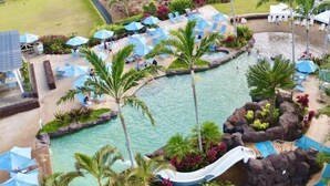 A pool area with lounge chairs, umbrellas, and a water slide. - Plantation House by Destination Kauai - Poipu Beach Estates, Central A/C, 3BD (Koloa)