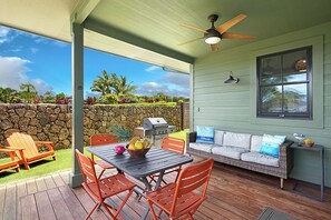 Enjoy al fresco dining and relaxation in this serene outdoor patio area with a dining table, grill, and comfortable seating.