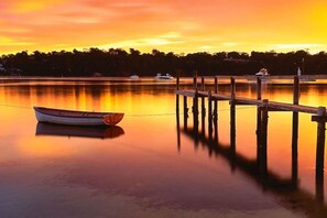 Un llac tranquil al capvespre amb un moll ia un vaixell.