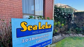 Señal para Sea Leka Holiday Units que anuncia unidades de 2 y 3 habitaciones con vistas al lago, gestionado por Merrimulla Realty.