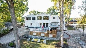 Une maison à deux étages avec une terrasse et une cour arri ère clôturée.