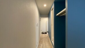 A narrow hallway with a wooden floor, a white door at the end, and a blue wall on one side. - Only 1 minute to subway station (G-18 Ginza Line) (台東区寿)