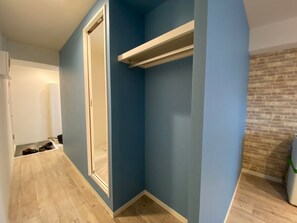 Un corridoio con una parete blu, un pavimento in legno e una porta bianca.