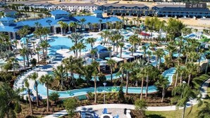 A resort with multiple swimming pools, palm trees, and a large water slide. - 20% OFF Weekly Stay/ 6Br/ Fireworks View (Davenport)