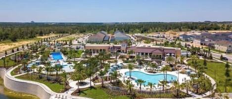 A resort with multiple buildings, a large central pool, and surrounding greenery.