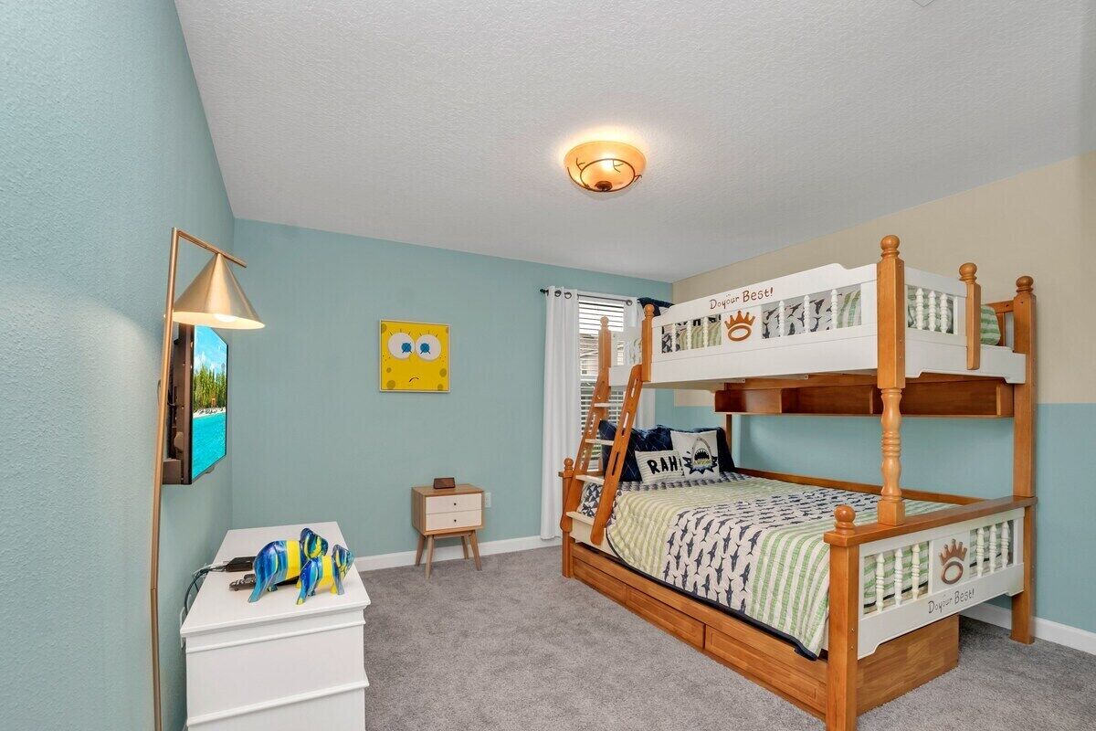 Una cama litera con dosel, una mesita de noche, una lámpara y un adorno en la pared.