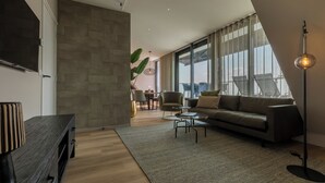 Una sala de estar moderna con un sofá, una mesa de centro y un televisor montado en la pared.