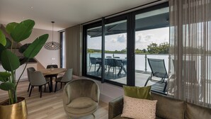 Una sala de estar moderna con un amplio ventanal corredero que da a una terraza exterior con piscina.