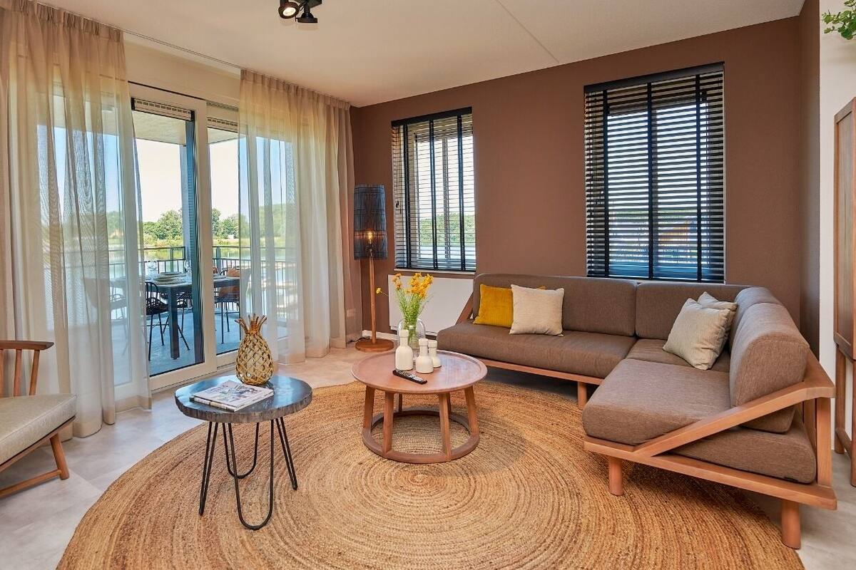 Un salon moderne avec un canapé, une table basse et une vue sur un balcon.