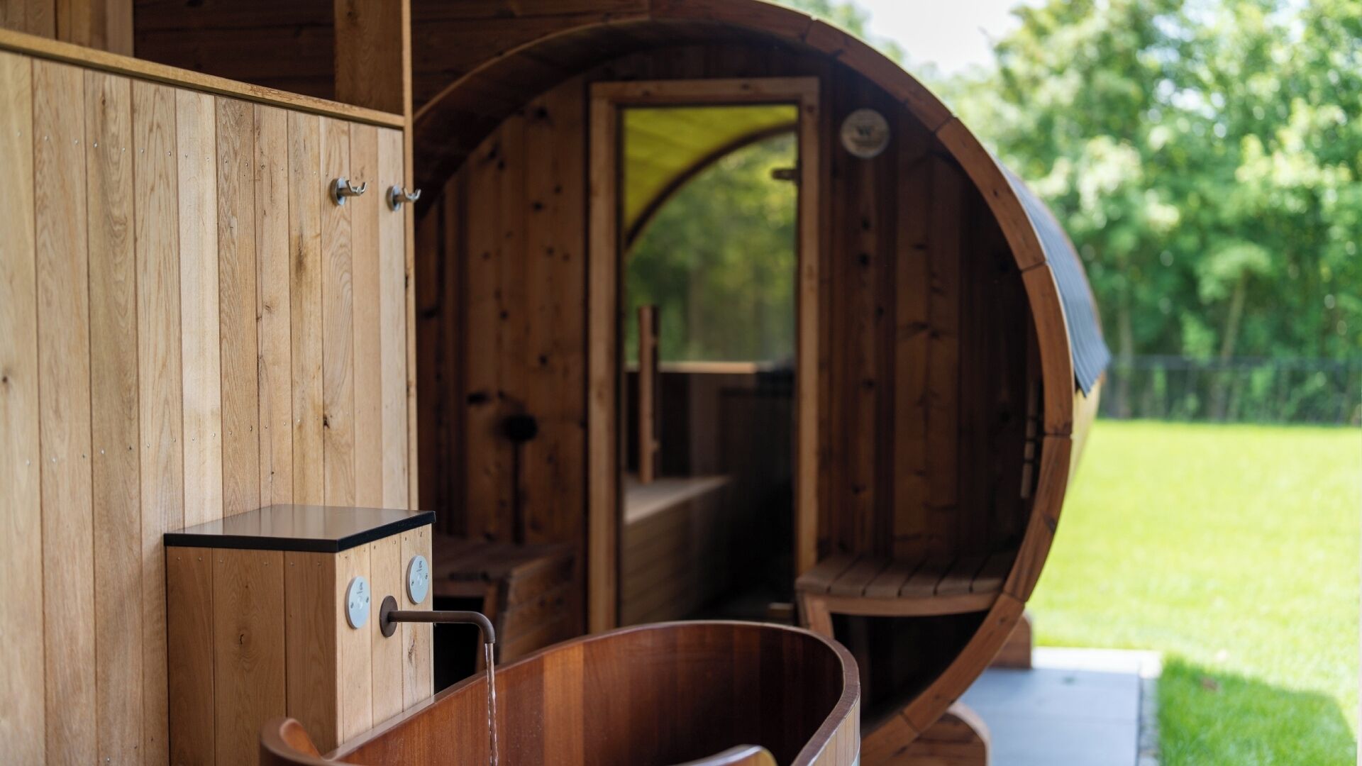 Una sauna de madera con un banco de madera y un balde.