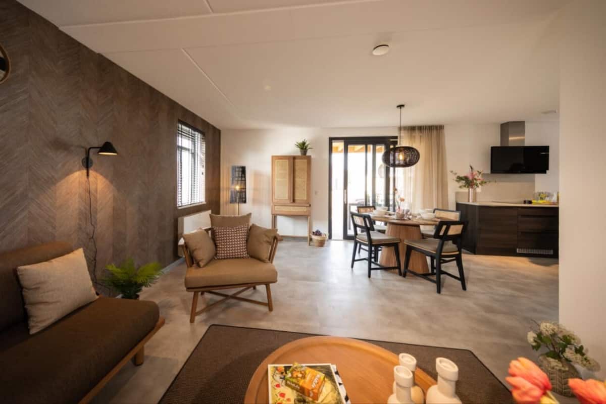 Un salon moderne comprenant un canapé, un coin repas et une cuisine.