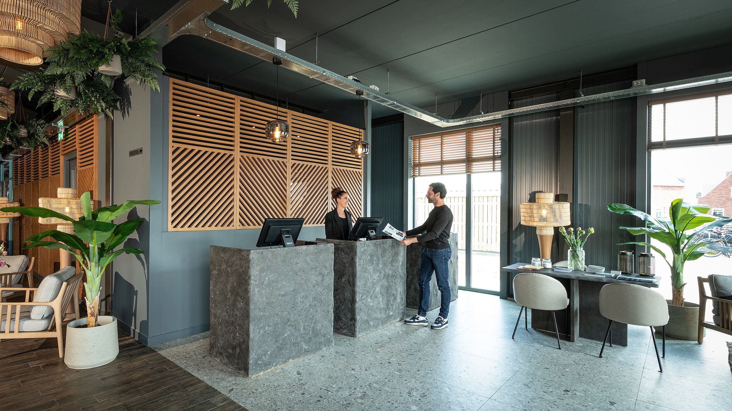 A reception area with a modern design, including a reception desk, seating area, and large windows.