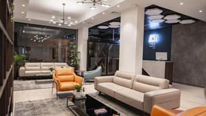 Un moderno vestíbulo de hotel con un sofá, sillones y una mesa de centro.