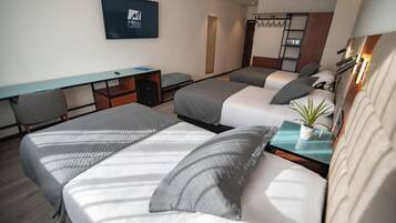 A hotel room with two beds, a desk, a TV, and a wardrobe.