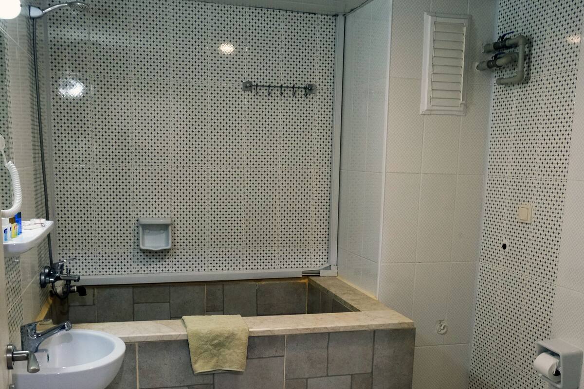 A modern bathroom with a freestanding bathtub, a sink, and a toilet.