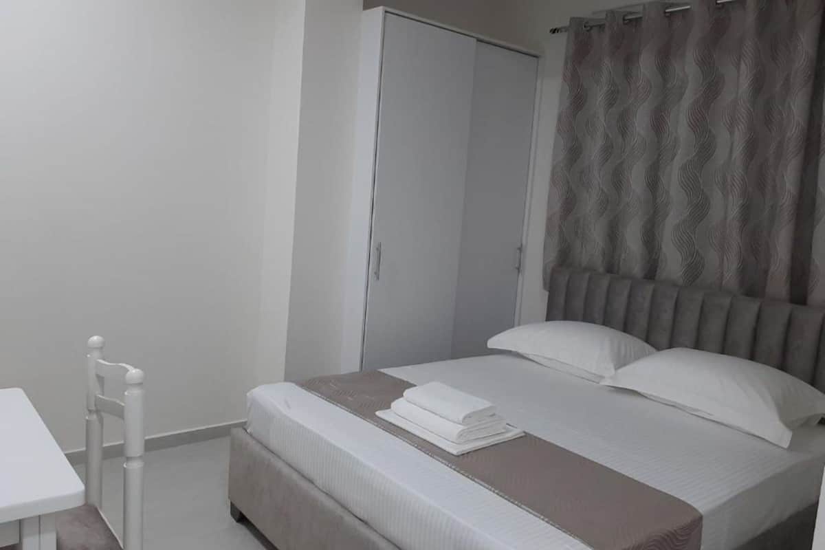 Un dormitorio con cama, mesita de noche y armario.
