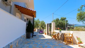Un patio con suelo de piedra, mobiliario exterior y vistas del entorno.