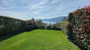 A well-maintained grassy area with a view of a lake and mountains in the background. - Casa Leòn Lake View (Verbania)
