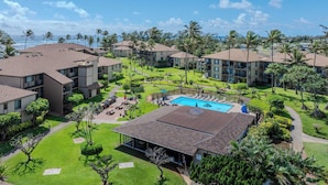 Un resort con varias edificaciones, una piscina y un césped cuidado.