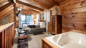 A wooden cabin with a bedroom, a bathroom, and a dining area. - Sweet Dreams - Romantic and Hot Tub (Sevierville)