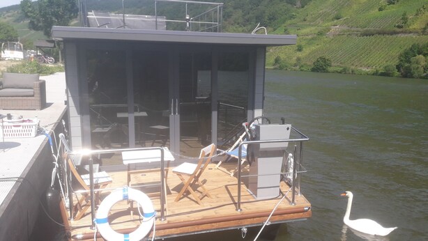 Ein Boot mit überdachter Deckfläche, Sitzgelegenheiten und einem Rettungsring.