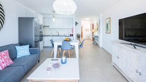 Una sala de estar moderna con sofá, mesa de centro y comedor.